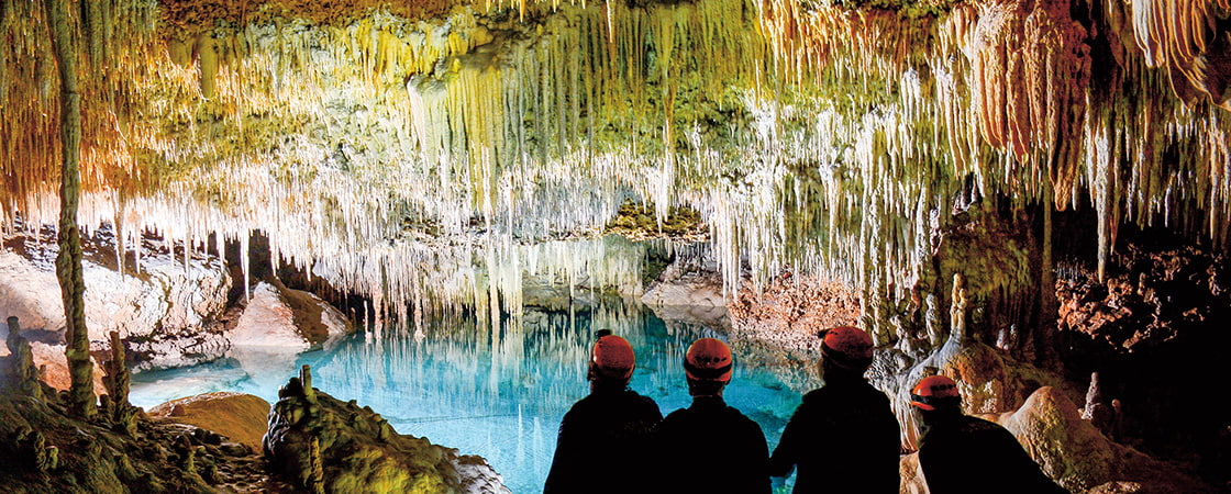 Image of people wearing helmets & exploring a cave