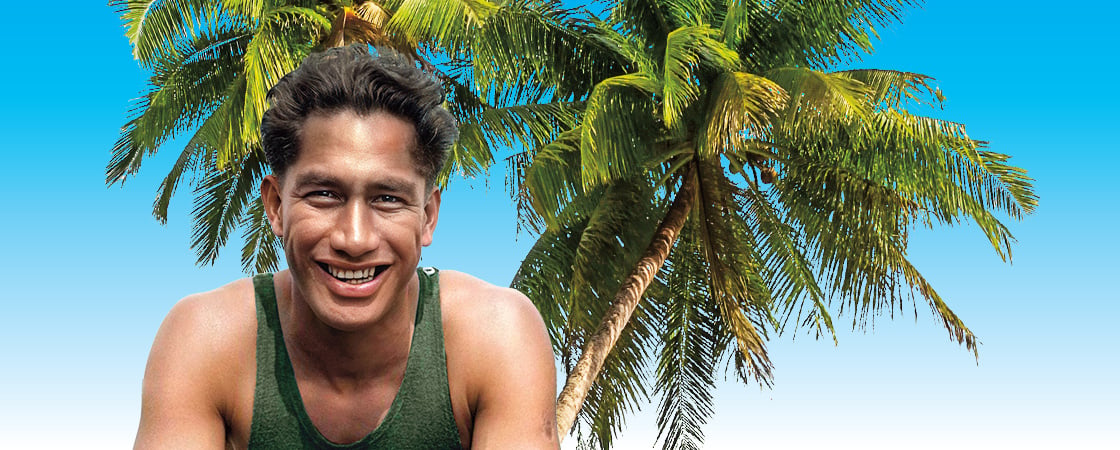 Image of a person smiling against backdrop of palm trees